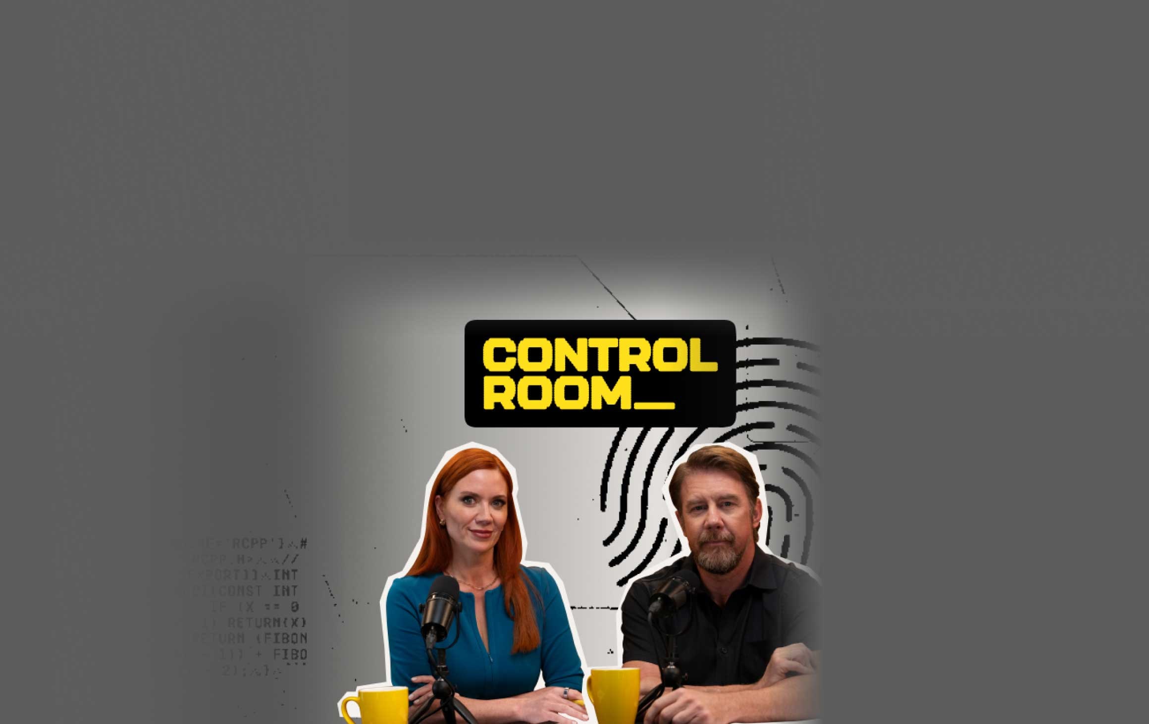 Man and woman sitting at a desk with microphones