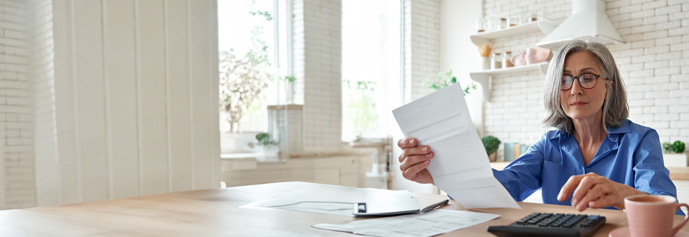 A woman examining documents to check for potential Medicare scams.