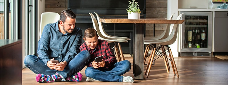 Dad and his son check their fantasy football scores after taking steps to protect their personal information.