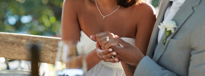 Picture of married couple at their wedding holding hands.