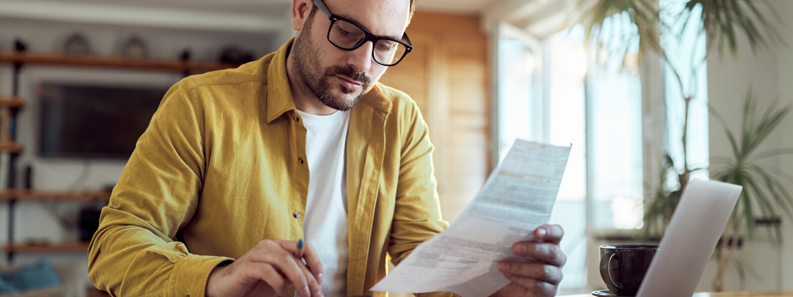 A picture of a man checking his statement for signs of credit card fraud