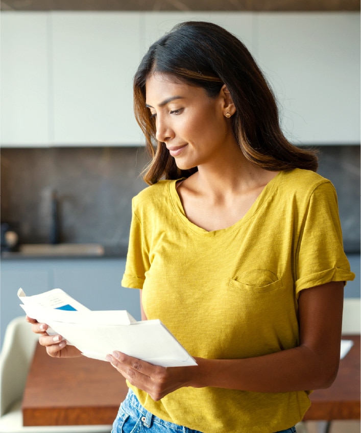 A woman checking her bills after learning about a potential data breach.