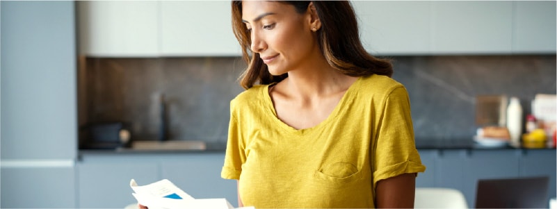 A woman checking her bills after learning about a potential data breach.