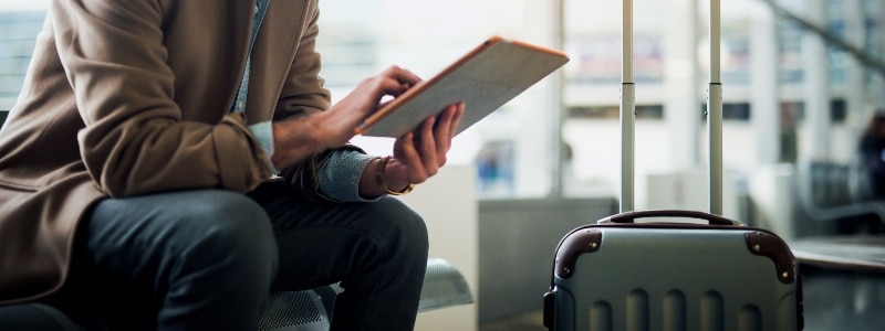 A person surfing on a tablet while at the airport.