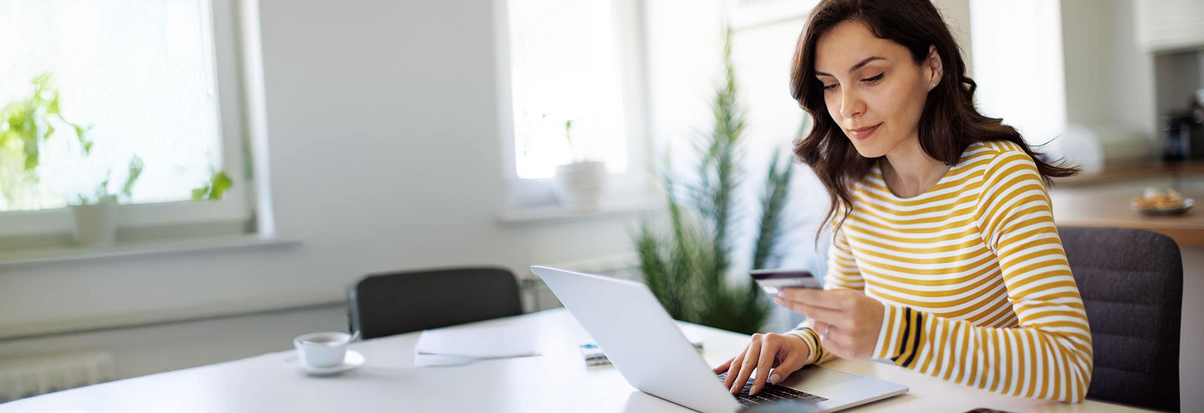Image of someone looking at a credit card, wondering if closing it will hurt their credit.