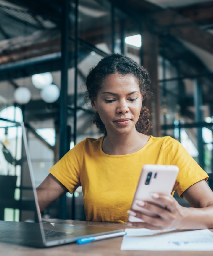 A woman reads about employment identity theft on her smartphone.