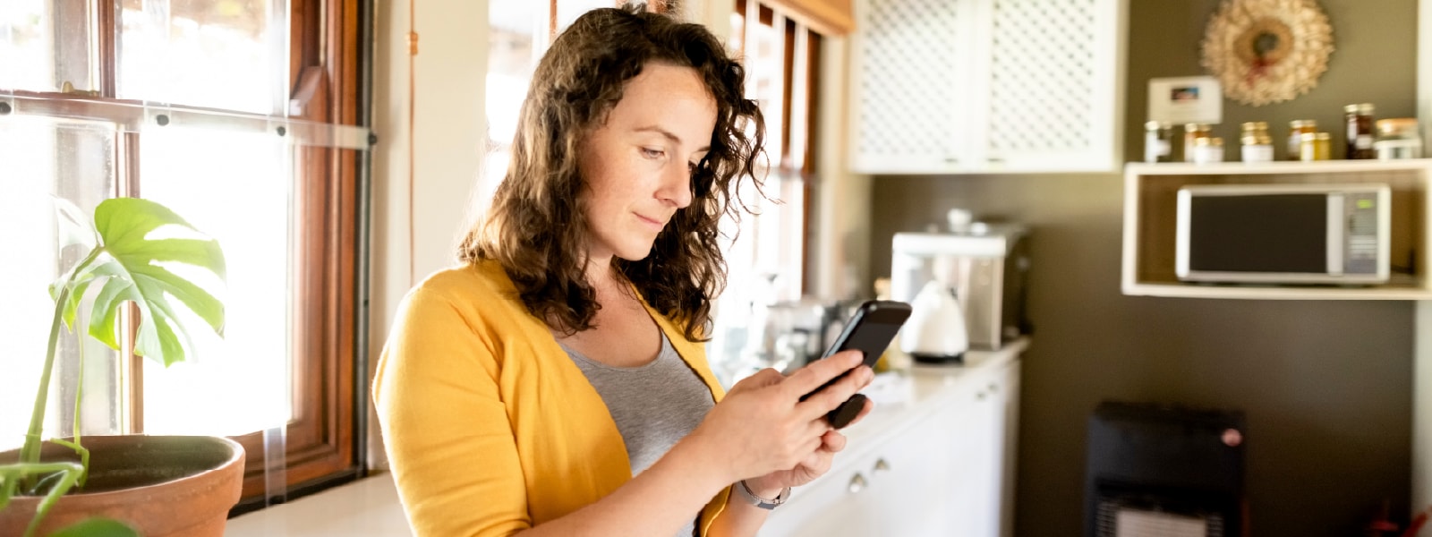 A woman looks at her phone while learning about Facebook Marketplace scams.