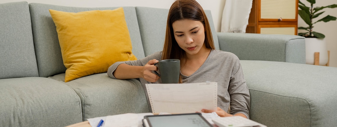 Image of a woman sitting at a coffee table with paperwork