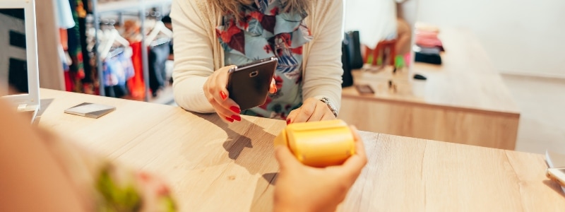 A woman pays for a transaction with her smartphone.