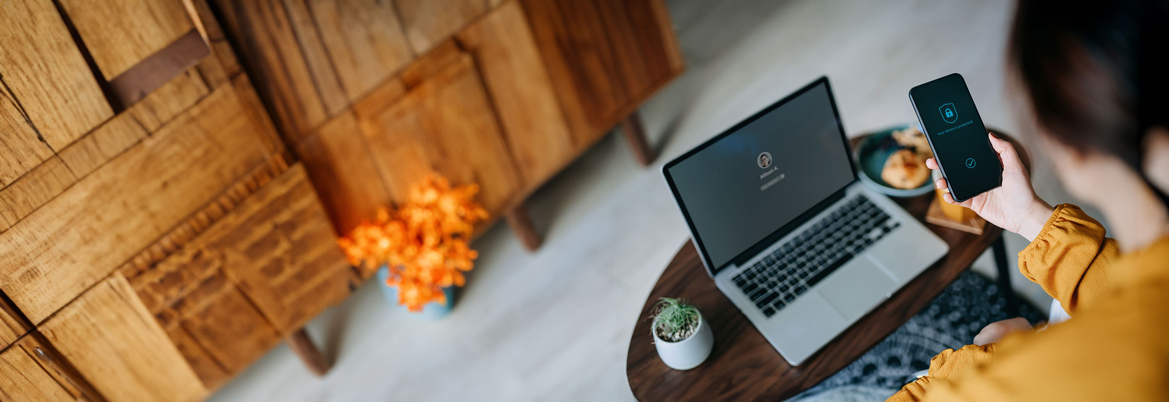 A person sitting at a desk with a laptop and mobile phone