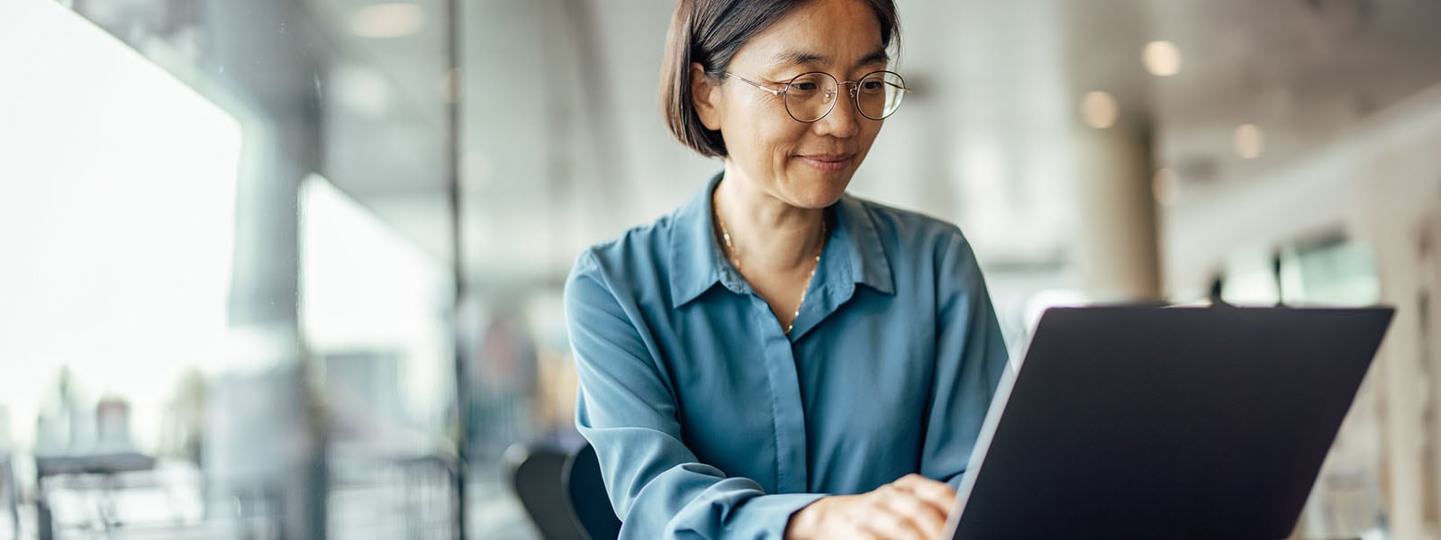 Woman using a laptop looking up tips for how to help prevent identity theft.