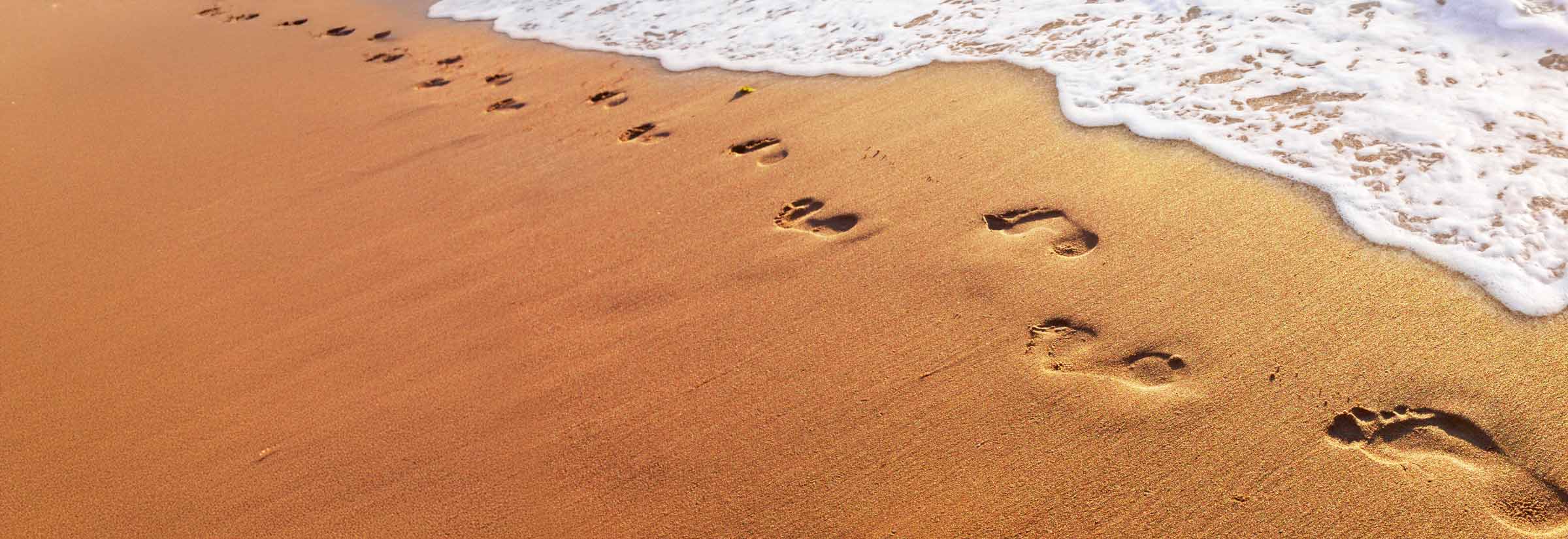 A trail of footprints in the sand.