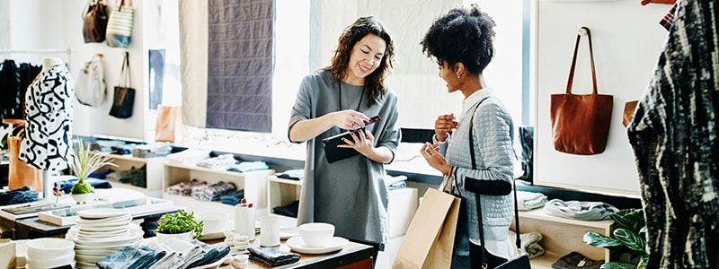 A woman pulls out her wallet to pay for a purchase at a local store.