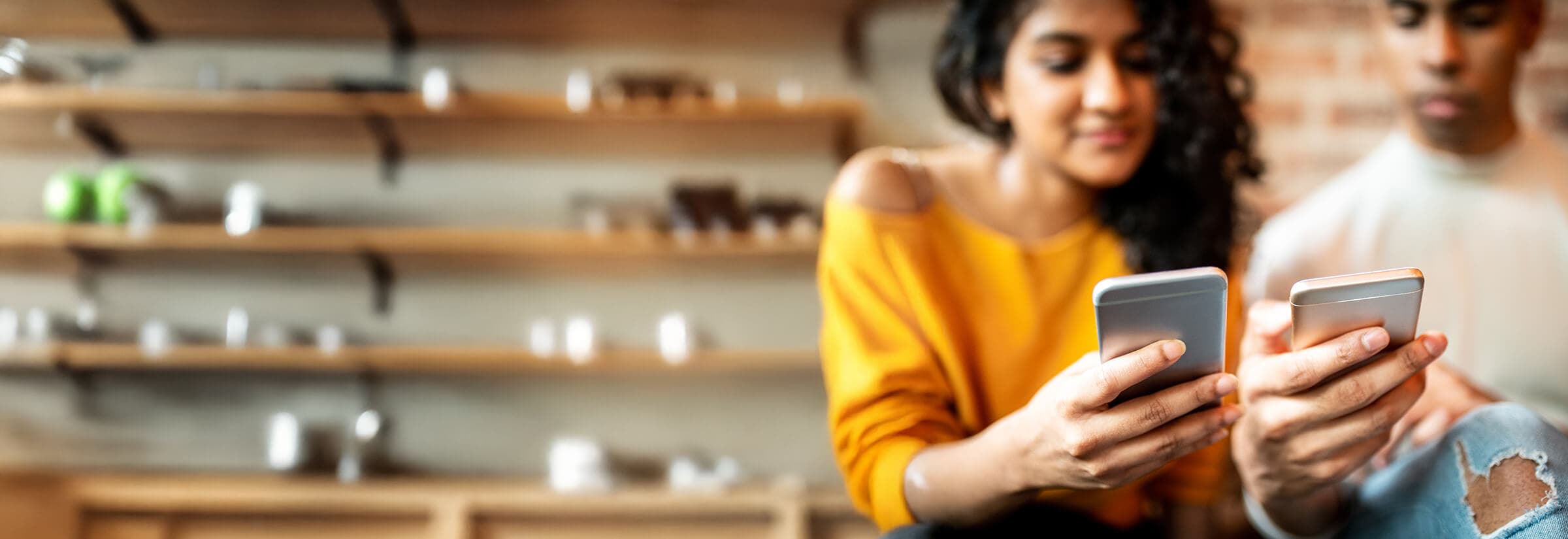 A couple on their smartphones, potentially using Venmo to send each other money.