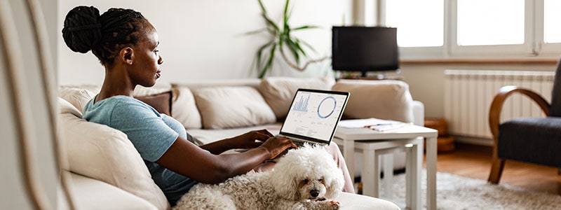 A woman looks at financial information on her computer while working to recover from parental identity theft.