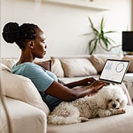 A woman looks at financial information on her computer while working to recover from parental identity theft.