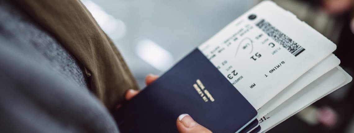 A person holding a passport and boarding pass.