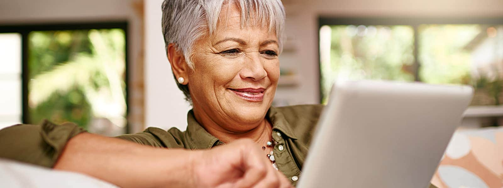 A woman with a tablet securely entering a password, demonstrating the importance of password security for online safety.