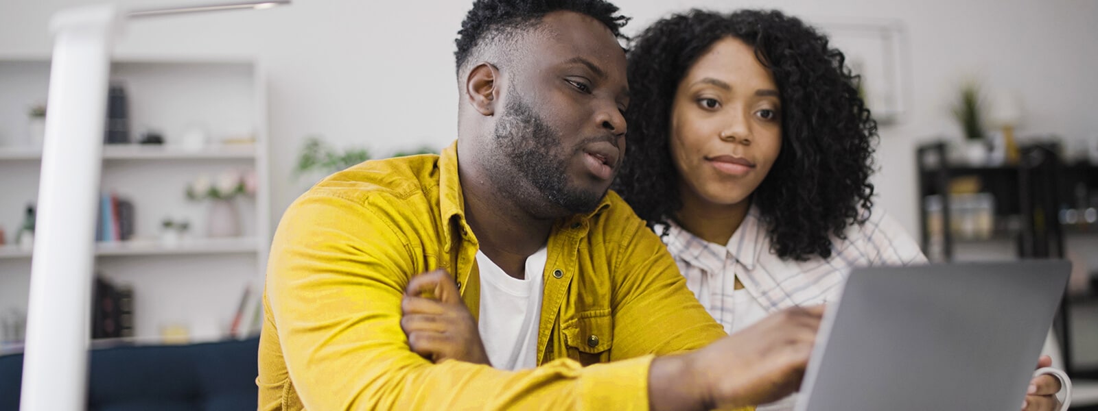 A couple looking at their computer learning about how to avoid real estate scams.