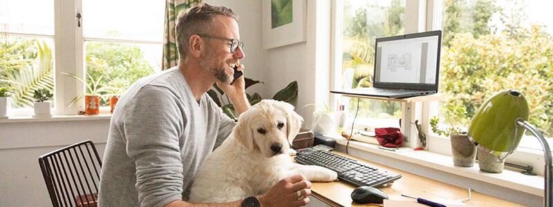 A man on the phone as he speaks to a scammer about his personal information.