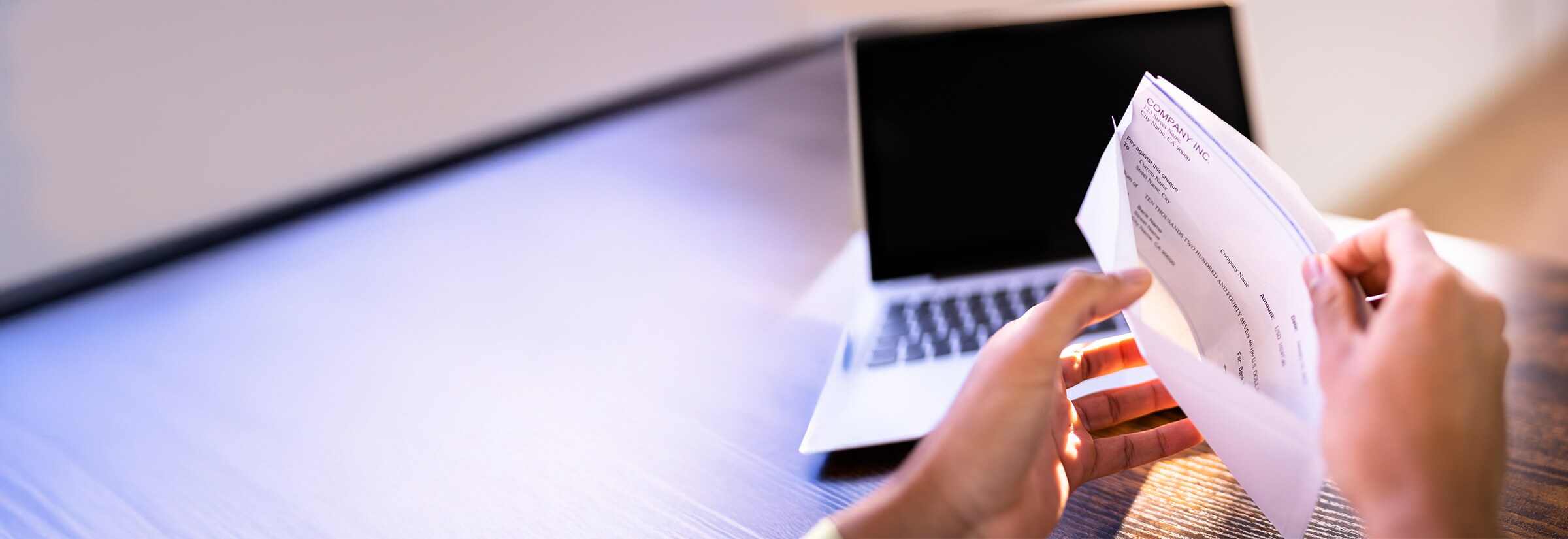 Person taking a check out of an envelope.
