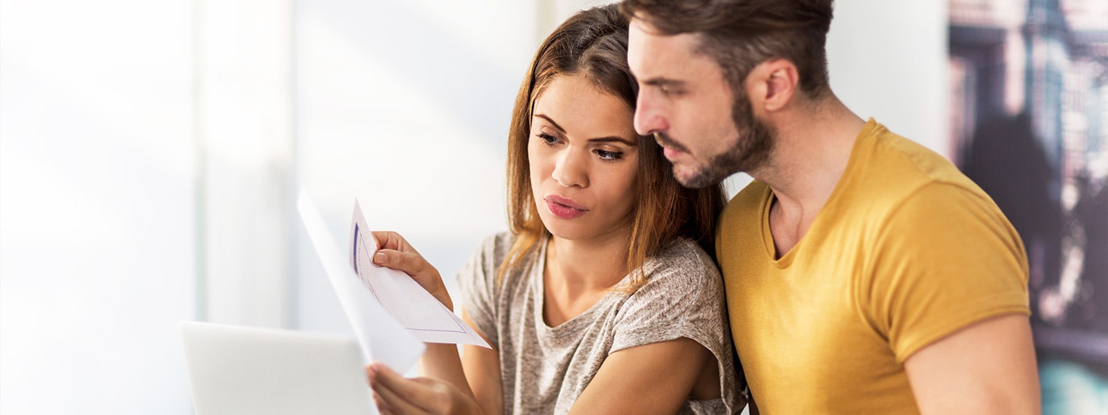 A couple examining a credit report document after learning the answer to the question, “What is a credit report?”