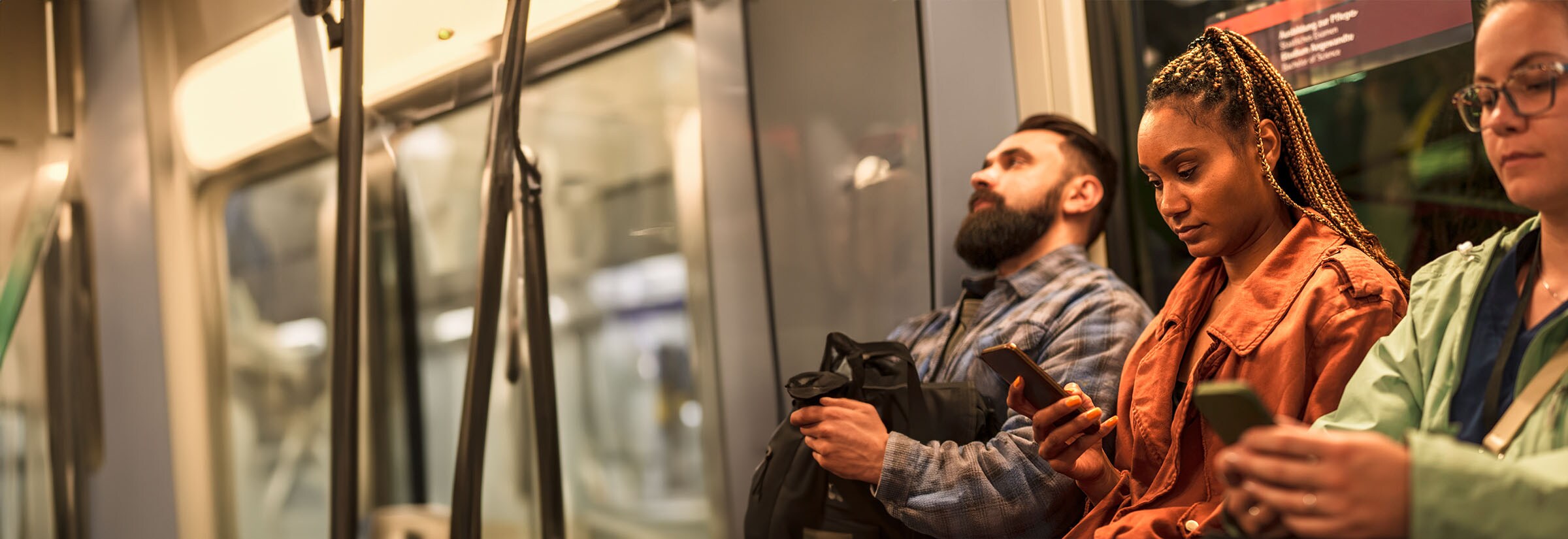 Passengers on a train using their smartphones are vulnerable to shoulder surfing.