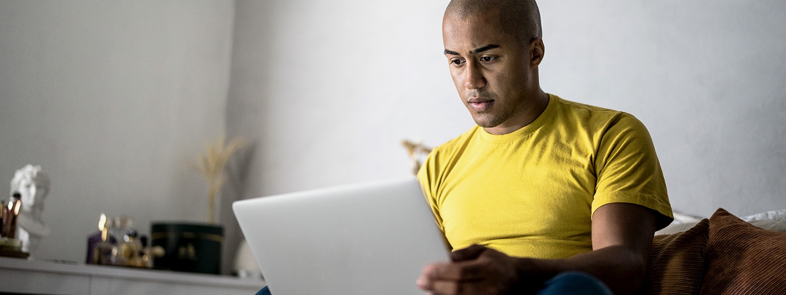 A man looking at his laptop trying to determine if he is looking at a Craigslist scam.