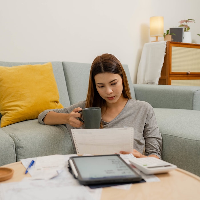 Image of a woman sitting at a coffee table with paperwork