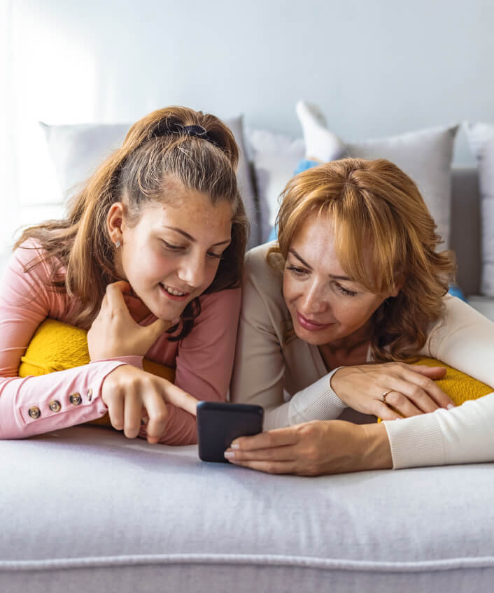 A picture of a child entering her information on her mother’s smartphone, potentially putting her at risk of family identity theft.