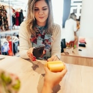 A woman pays for a transaction with her smartphone.