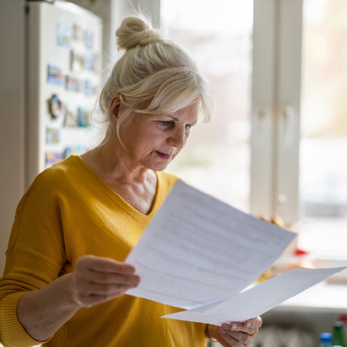 Woman looking at papers learning about how common identity theft is.