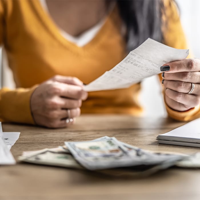 A woman holding a receipt at a desk