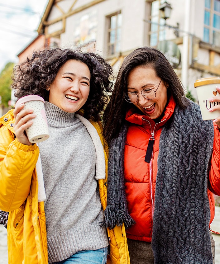 Two friends grab coffee after learning the answer to the question, "Is identity theft protection worth it?"