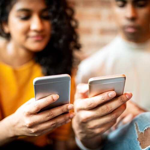 A couple on their smartphones, potentially using Venmo to send each other money.