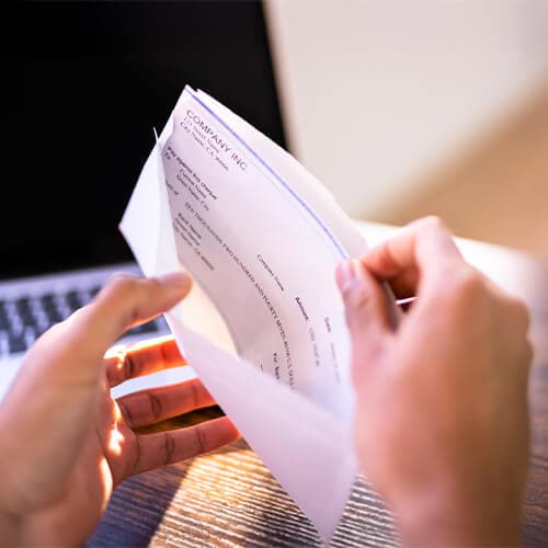 Person taking a check out of an envelope.
